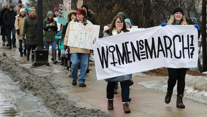 People walked along Lake Street during the Woman's March in Eau Claire, Wis.,Saturday.
