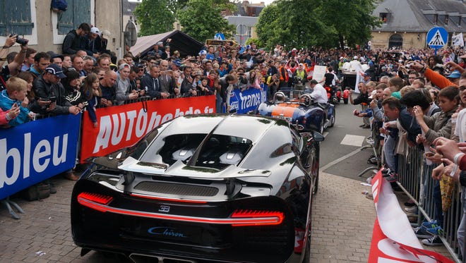 A Bugatti Chiron is taken through the driver's parade while the crowd takes photos in awe at the surprise showing at the 2016 Le Mans.