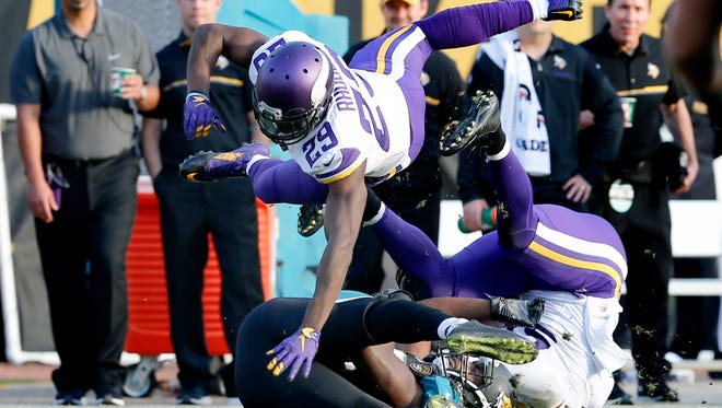 Minnesota Vikings outside linebacker Anthony Barr (55) and cornerback Xavier Rhodes (bottom right) combine to stop the catch by Jacksonville Jaguars tight end Neal Sterling (bottom left) during the second half of  an NFL football game at EverBank Field.
