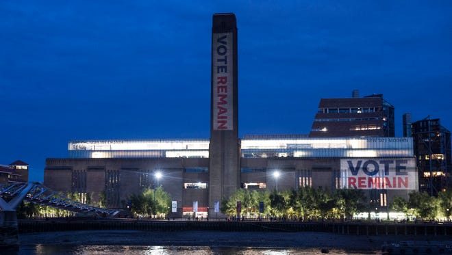 An exterior view shows the Tate Modern Gallery illuminated with 'Vote Remain' in London on June 21, 2016.