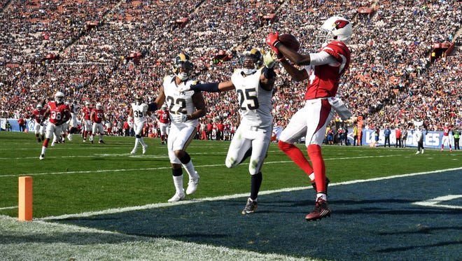 Cardinals wide receiver J.J. Nelson (14) is defended by Rams cornerback Trumaine Johnson (22) and safety T.J. McDonald (25) in the second quarter.