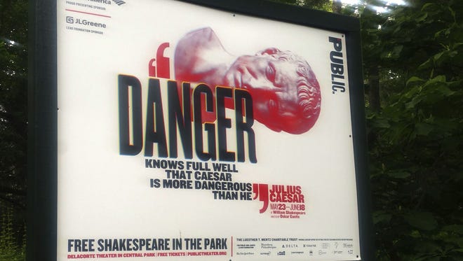 In this photo taken on June 7, 2017, 'Danger knows full well that Caesar is more dangerous than he,' reads a sign promoting The Public Theater's production of Julius Caesar in New York's Central Park.