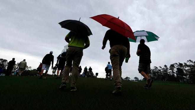 Patrons leave the course after the course is evacuated due to inclement weather in the forecast during a practice round at Augusta National Golf Club.