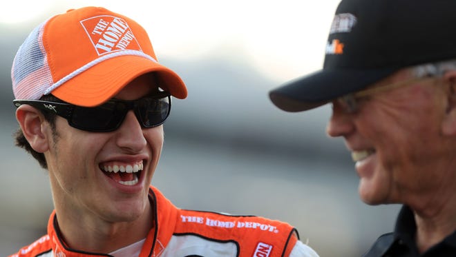 Joey Logano laughs with team owner Joe Gibbs during qualifying for the NASCAR Sprint Cup Series Coca-Cola 600 at Charlotte Motor Speedway on May 26, 2011 in Charlotte, North Carolina.