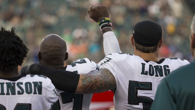 Malcolm Jenkins of the Philadelphia Eagles holds his fist in the air while Chris Long puts his arm around him during the national anthem prior to the preseason game against the Buffalo Bills at Lincoln Financial Field on August 17, 2017 in Philadelphia, Pennsylvania.