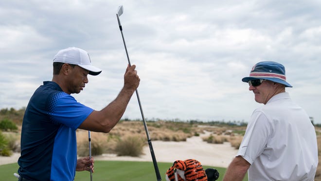 Tiger Woods picks out a club in front of caddie Joe LaCava on the eighth hole during Monday's practice round of the Hero World Challenge.