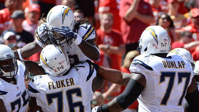 San Diego Chargers running back Melvin Gordon (28) is congratulated by guard D.J. Fluker (76) and guard Chris Hairston (75) after scoring a touchdown against Kansas City Chiefs linebacker Derrick Johnson (56) in the first half at Arrowhead Stadium.