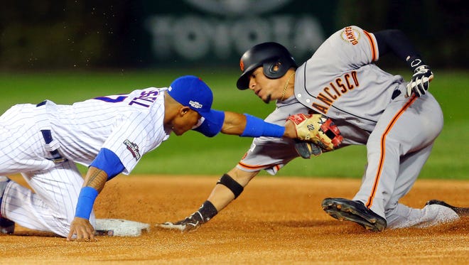 Game 1 in Chicago:  Cubs shortstop Addison Russell tags out Giants center fielder Gorkys Hernandez on an attempted steal during the first inning.