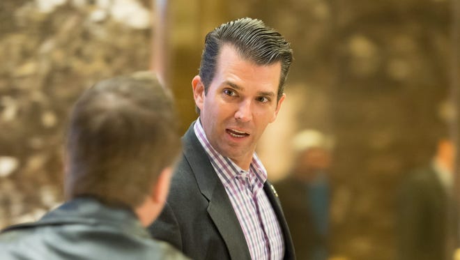 Donald Trump, Jr. talks with someone upon his arrival in the lobby of Trump Tower.