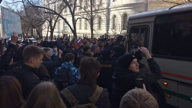 In this handout photo provided by Kira Yarmysh, Alexei Navalny press secretary, people block the way for a police bus, where Alexei Navalny is kept in Moscow, Russia on March 26, 2017.