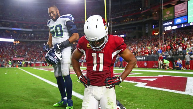 Arizona Cardinals wide receiver Larry Fitzgerald (11) and Seattle Seahawks linebacker K.J. Wright (50) react following the game at University of Phoenix Stadium.