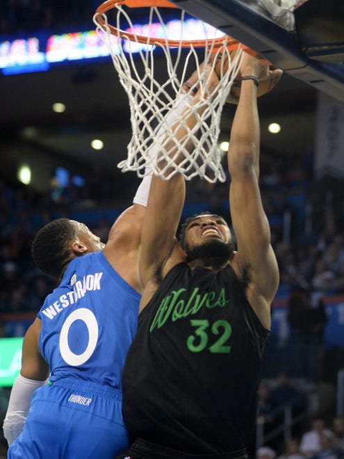 Thunder guard Russell Westbrook (0) blocks a dunk attempt by Timberwolves center Karl-Anthony Towns (32) during the first quarter.