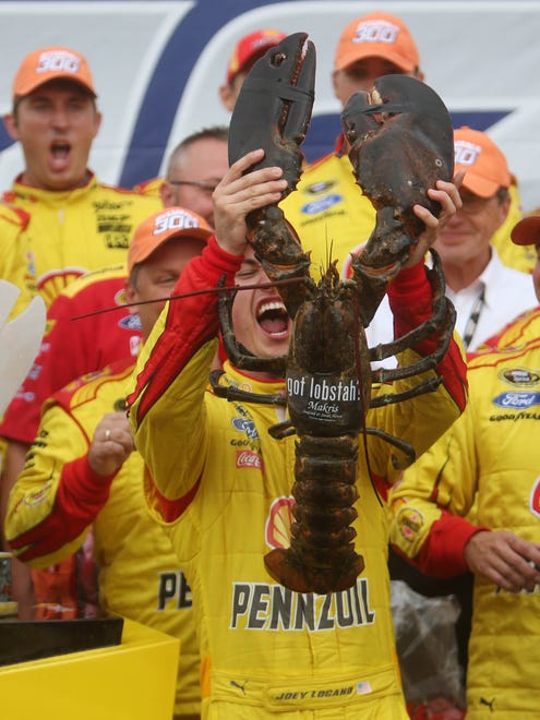 NASCAR Sprint Cup Series driver Joey Logano reacts as he is presented with a lobster after winning the Sylvania 300 at New Hampshire Motor Speedway.