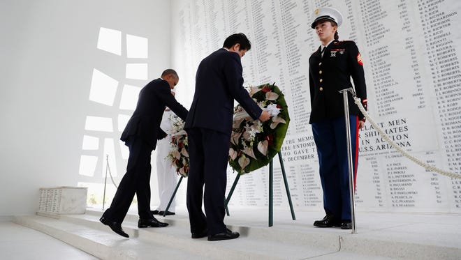 Obama and Japanese Prime Minister Shinzo Abe participate in a wreath-laying ceremony at the USS Arizona Memorial, part of the World War II Valor in the Pacific National Monument, in Joint Base Pearl Harbor-Hickam, Hawaii, on Dec. 27, 2016.