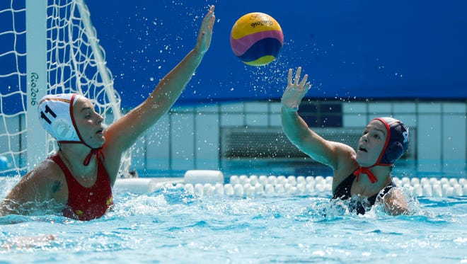 Rachel Fattal of United States, right,  passes the ball away from Maica Garcia Godoy of Spain   during a women's water polo preliminary round game in the Rio 2016 Summer Olympic Games at Maria Lenk Aquatics Centre.