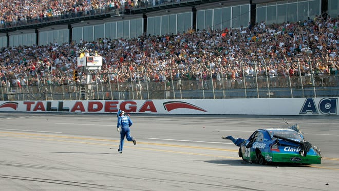 After climbing from his mangled car, Carl Edwards gets a standing ovation from the crowd as he runs across the finish line during the Aaron's 499 at Talladega Superspeedway on April 26, 2009.