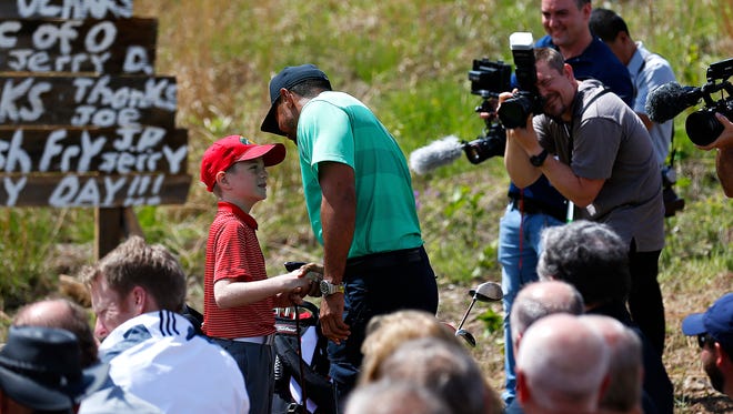 Professional golfer Tiger Woods (right) shakes the hand of Johnny Morris' great nephew Hudson during a press event announcing a new golf course designed by Tiger Woods with the support of Johnny Morris in Hollister, Mo. on April 18, 2017.