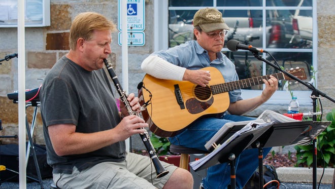 Local musicians Rick Grothaus (left) and Jeff Leonard entertain visitors at the Donna Lexa Memorial Art Fair in Wales on Saturday, August 19, 2017. The annual event features arts and crafts, food, children's activities, live entertainment and more.