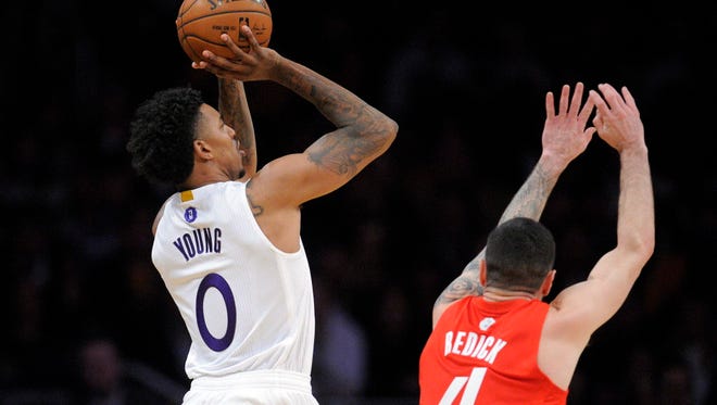 Lakers guard Nick Young (0) shoots against the defense of Clippers guard J.J. Redick (4) during the first half.