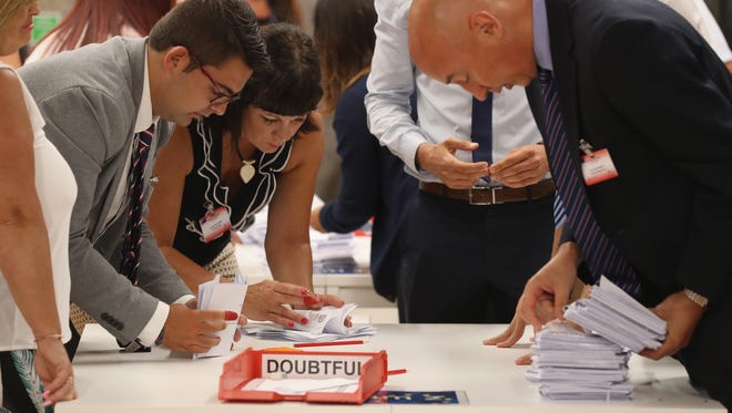 Referendum workers verify the validity of ballots in the verification center before counting at Gibraltar University after the closing of polling stations on the day of the EU Referendum in Gibraltar.