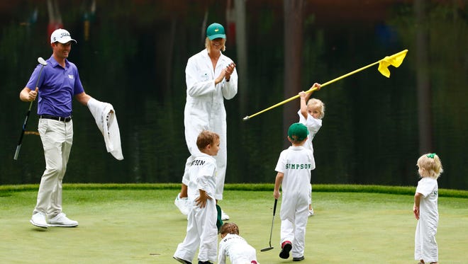 Webb Simpson reacts as his children play with Bubba Watson's children during the Par 3 Contest.