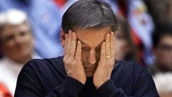 Former Iowa State coach Larry Eustachy holds head in his hands late in a Feb. 12, 2003 game at Texas Tech. Less than three months later, Eustachy resigned.
