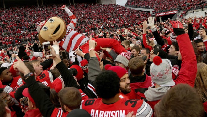 Brutus the Buckeye, Ohio State's mascot, is lifted into the air by Ohio State fans after thousands of them swarmed the field celebrating their team's win in two overtimes, 30-27, over Michigan at Ohio Stadium on Saturday, Nov. 26, 2016.
