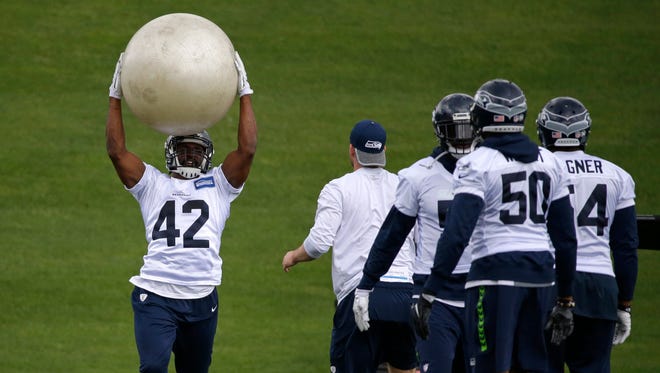 Seattle Seahawks linebacker Arthur Brown (42) lifts an inflatable ball during NFL football practice, Friday, June 9, 2017, in Renton, Wash.