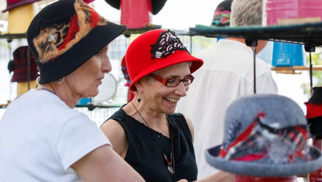 Elaine Hemzacek (left) of Chicago and Fe Petterson of Oconomowoc shop for hats during the 47th annual Oconomowoc Festival of the Arts in Fowler Park on Saturday, August 19, 2017.