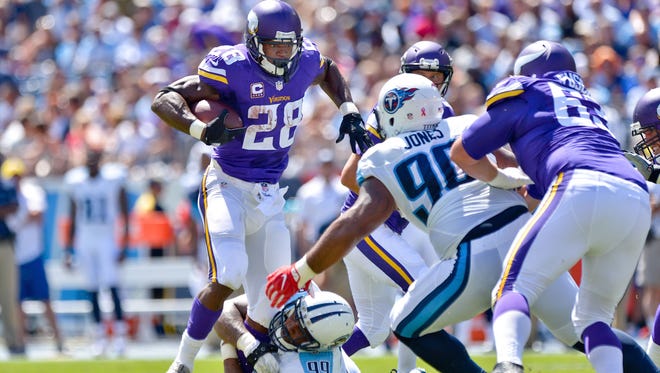Minnesota Vikings running back Adrian Peterson (28) is tackled by Tennessee Titans defensive end Jurrell Casey (99) during the first half at Nissan Stadium.
