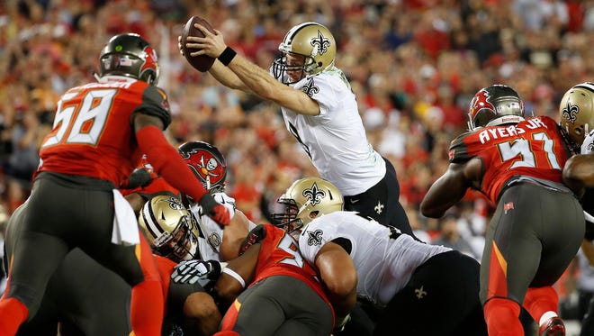 Saints quarterback Drew Brees (9) leaps for first down against the Buccaneers.