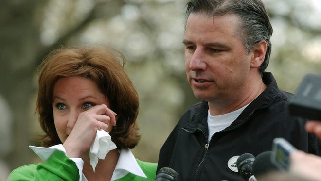 Larry Eustachy stands with his wife, Stacy, as he speaks to reporters following a news conference announcing his resignation as Iowa State's head basketball coach, Monday, May 5, 2003, in Ames, a week after the publication of photos of him drinking and partying with college students in Missouri and Kansas.