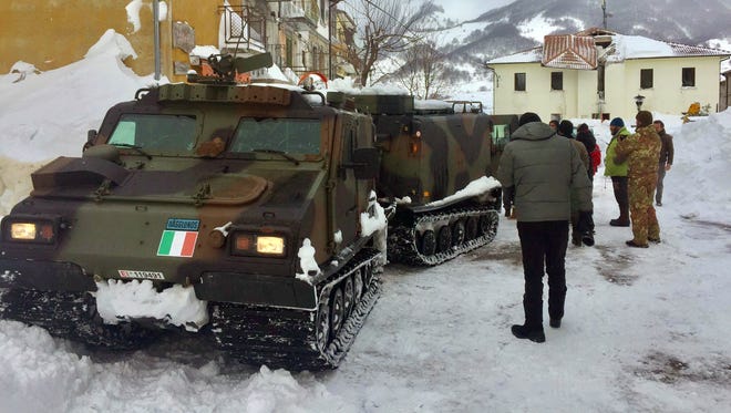 An Italian army vehicle arrives in Campotosto after a series of quakes destroyed buildings.