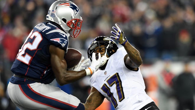 Patriots safety Devin McCourty (32) intercepts a first-half pass intended for Ravens receiver Mike Wallace (17).