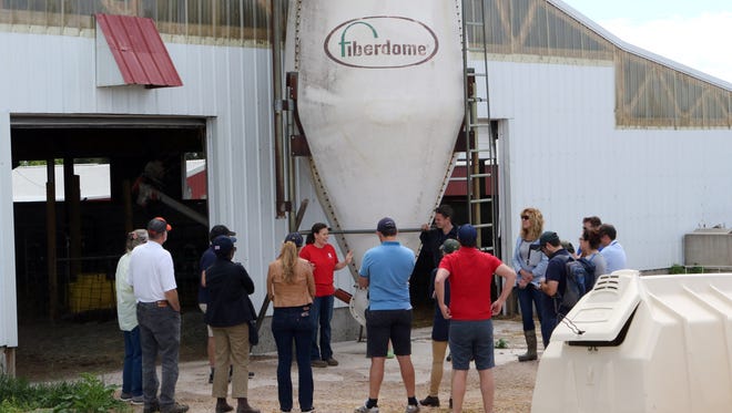 Ashley Schlender (center) talks to 11 farmers from around the world during a tour of Nuffield Scholars at their Jefferson County farm, Never Rest Dairy, on June 19. It's the first time the tour stopped in Wisconsin during its U.S. tour.