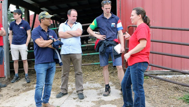 Ashley Schlender (center) talks to farmers from around the world during a tour of 11 Nuffield Scholars at their Jefferson County farm, Never Rest Dairy, on June 19. It's the first time the tour stopped in Wisconsin during its U.S. tour.