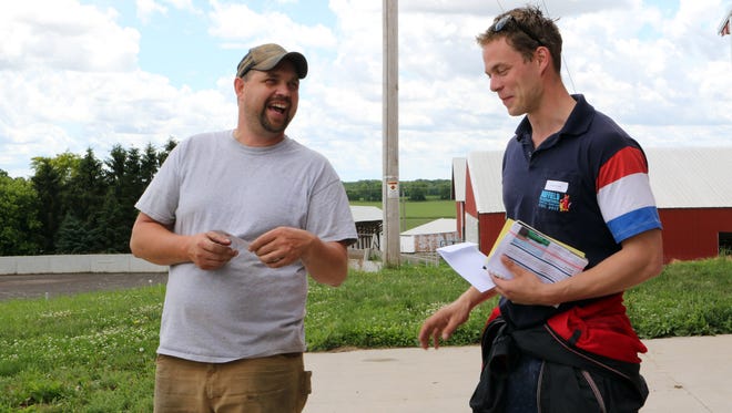 Troy Schlender (left) gets tokens of appreciation from Jaco de Groot, one of 11 Nuffield scholars visiting Never Rest Dairy on June 19. The scholars stopped at the farm as part of a one day, three-county tour in Wisconsin, the last part of the group's world-wide tour.