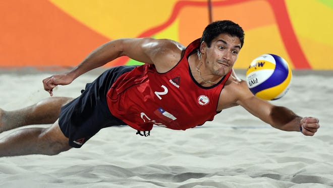 Choaib Belhaj Salah of Tunisia hits the ball against Russia during the men's beach volleyball preliminary round.