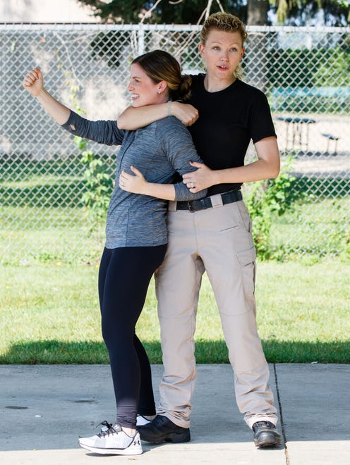 Waukesha County Sheriff's Deputy Sarah Kralovetz (right) demonstrates self defense tactics with personal trainer Maren Stodolka during a Community Self Defense Workshop at Indian Head Park in Mukwonago on Saturday, August 19, 2017. The workshop, hosted by Perfect Fit fitness studio, featured instruction on verbal and physical self defense tactics.