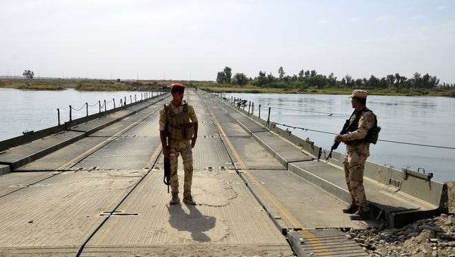 Iraqi soldiers stand guard in the entrance of a pontoon bridge over the Tigris river on the outskirts of Rashediya, north of Mosul, Iraq 23 May 2017.