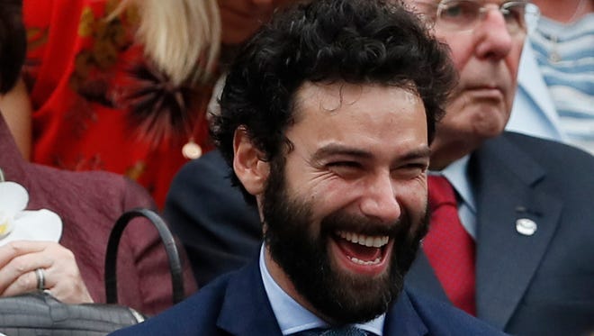 Actor Aidan Turner laughs as he waits for the start of the Women's Singles final match on day twelve.