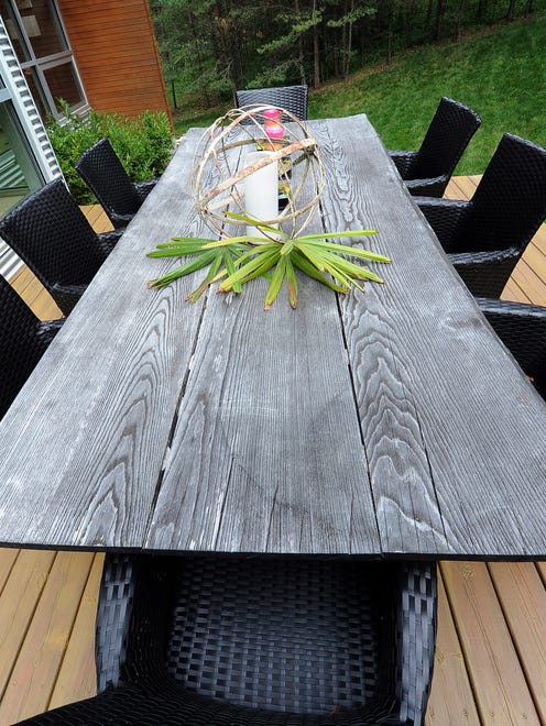 A table made from reclaimed wood sits on the side patio.