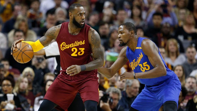 Cleveland Cavaliers forward LeBron James is guarded by Golden State Warriors forward Kevin Durant at Quicken Loans Arena.