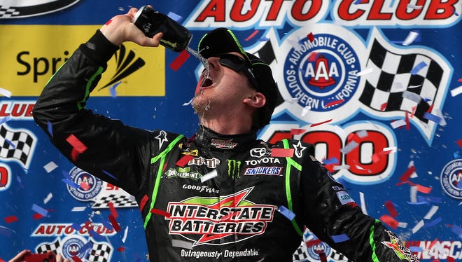 Busch celebrates in Victory Lane after winning the NASCAR Sprint Cup Series Auto Club 400 at Auto Club Speedway on March 23, 2014 in Fontana, California.