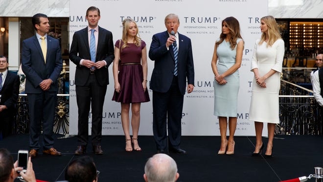 Donald Trump, accompanied by his wife Melania Trump second from right and his children from left, Donald Jr., Eric, Tiffany and Ivanka, speaks during the grand opening of the Trump International Hotel- Old Post Office, in Washington.