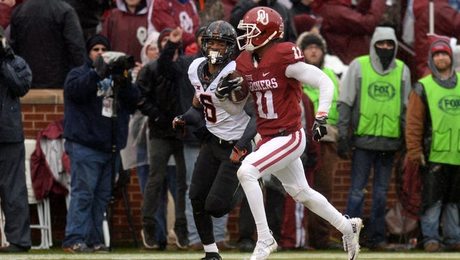 Oklahoma wide receiver Dede Westbrook runs for a touchdown while pursued by Oklahoma State cornerback Ashton Lampkin.