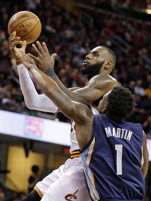 Cleveland Cavaliers' LeBron James is fouled by Memphis Grizzlies' Jarell Martin (1) in the first half of an NBA basketball game Tuesday, Dec. 13, 2016, in Cleveland. (AP Photo/Tony Dejak)