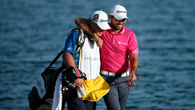 Jason Day hugs caddie Colin Swatton as they walk to the 18th green during the final round of the 2016 Players Championship at TPC Sawgrass - Stadium Course on May 15.