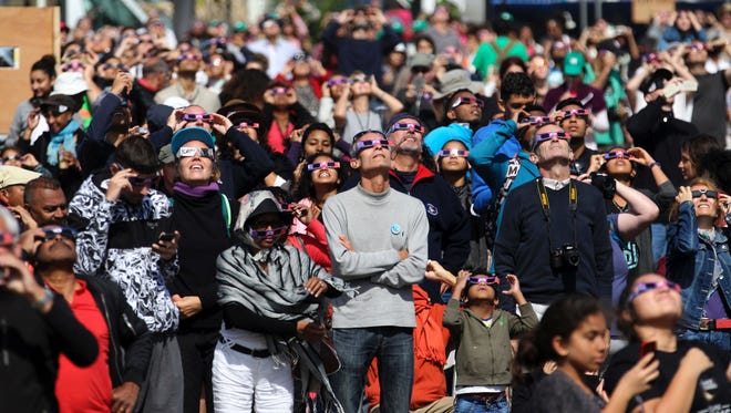 People look through eclipse viewing glasses, telescopes and cameras during an annular solar eclipse, on Sept. 1, 2016, in Saint-Louis, on the Indian Ocean island of La Reunion. Stargazers in south and central Africa were treated to a spectacular solar eclipse on Sept. 1, 2016 when the Moon wanders into view to make the Sun appear as a "ring of fire", astronomers say. The phenomenon, known as an annular solar eclipse, happens when there is a near-perfect alignment of the Earth, Moon and Sun. But unlike a total eclipse, when the Sun is blacked out, sometimes the Moon is too far from Earth, and its apparent diameter too small, for complete coverage.