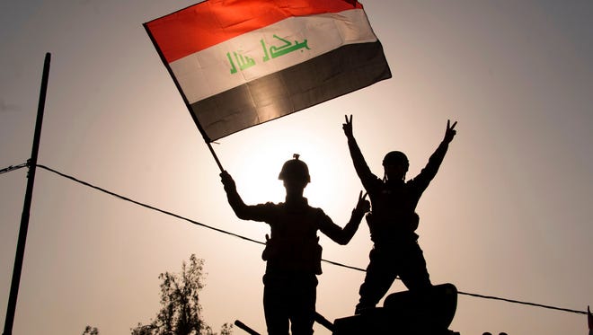 Iraq's federal police members wave Iraq's national flag as they celebrate in the Old City of Mosul on July 9, 2017 after the government's announcement of the "liberation" of the embattled city. 
Iraq declared victory against the Islamic State group in Mosul on July 9 after a grueling months-long campaign, dealing the biggest defeat yet to the jihadist group.